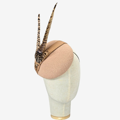 Beige headpiece  with feather accents on a mannequin head against a white background