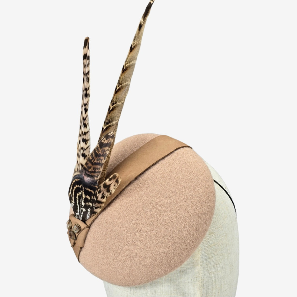 Beige felt pillbox hat with pheasant feathers and a leather trim