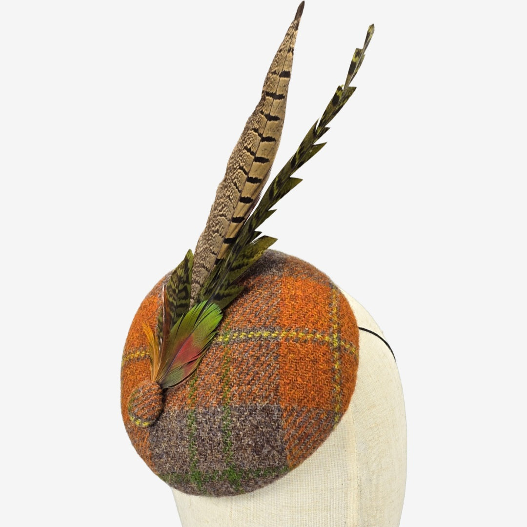 Checkered harris tweed hat with feathers on a white background