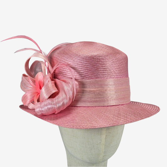 Pink straw hat with decorative silk abaca adornment on a mannequin head against a white background