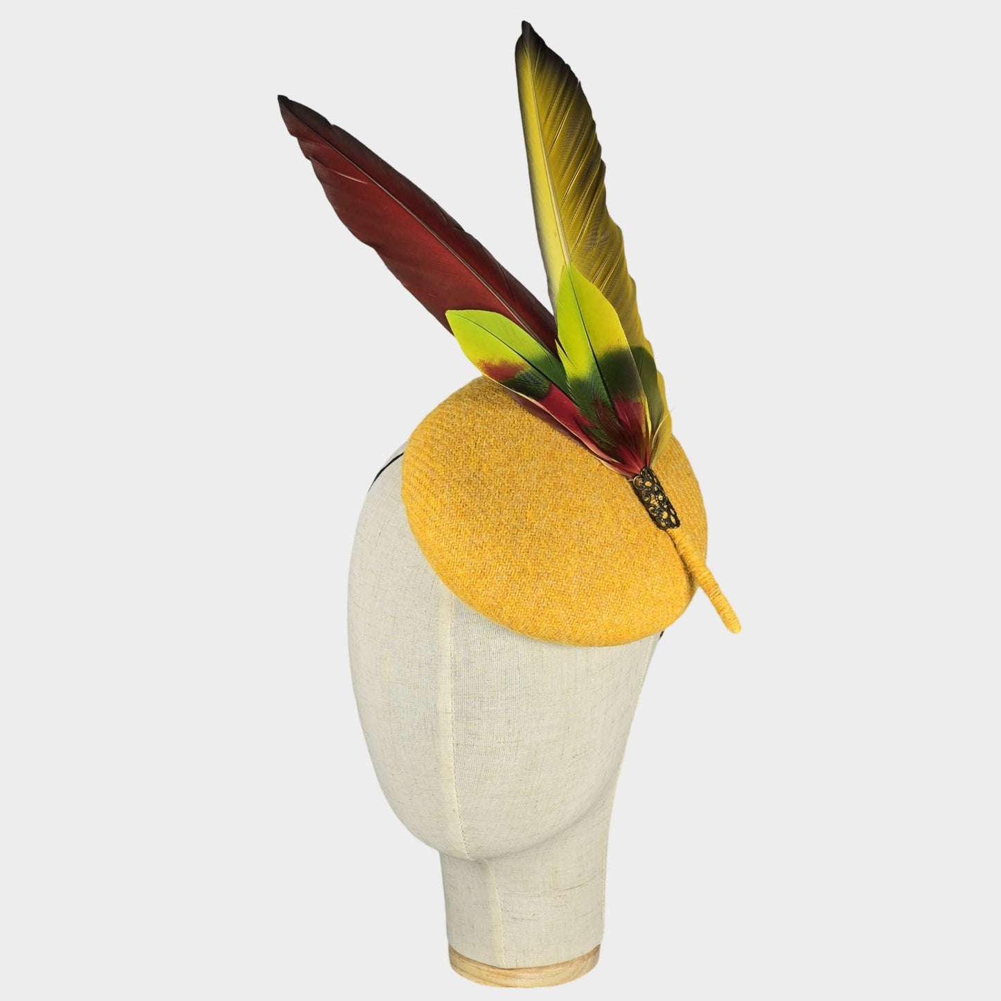 Yellow Harris tweed pillbox hat with red Macaw feathers