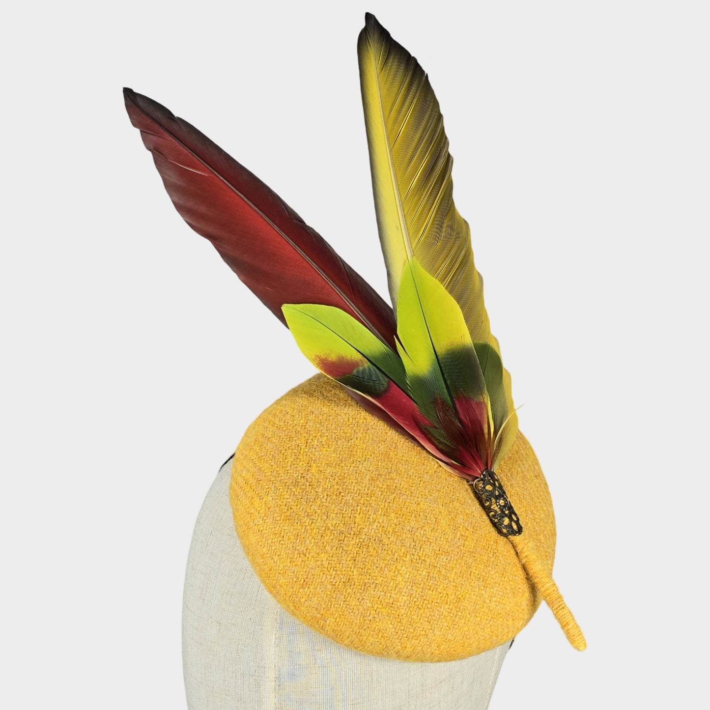 Yellow Harris tweed pillbox hat with red Macaw feathers
